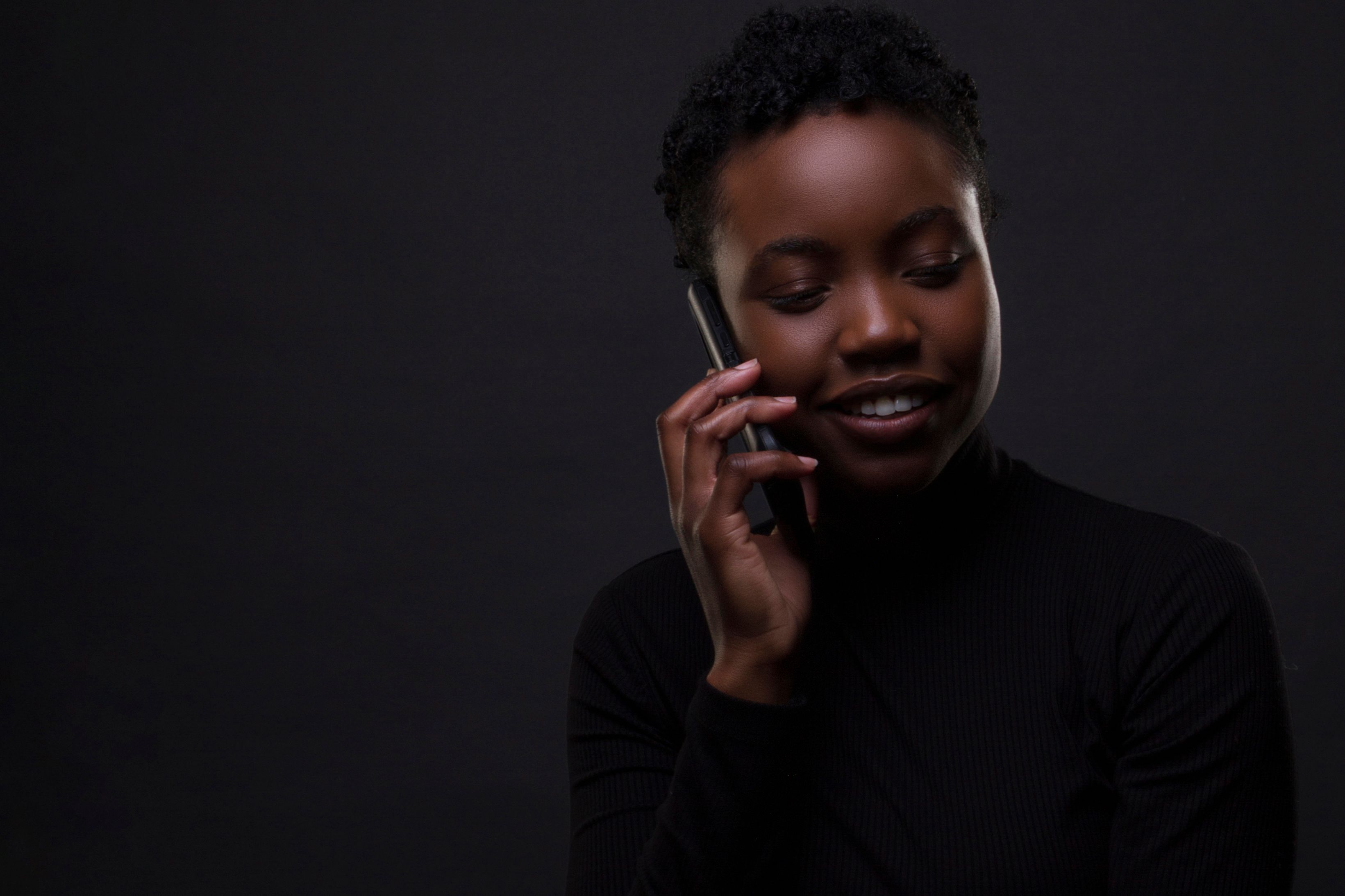 A woman smiling while speaking on the phone